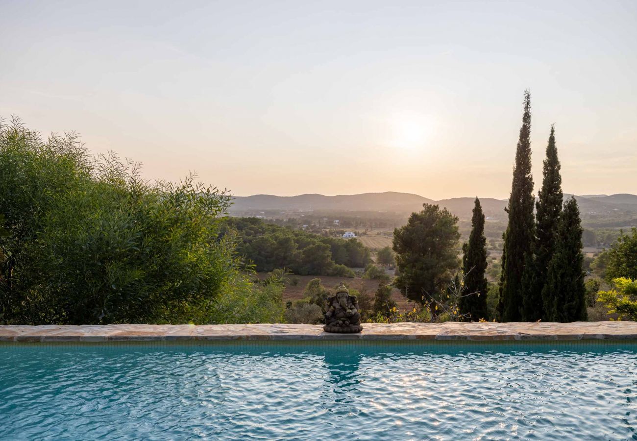 Puesta de sol con el espacio natural de Ibiza de fondo desde la piscina privada